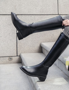 Női térdig érő csizma cipzárral és csatokkal