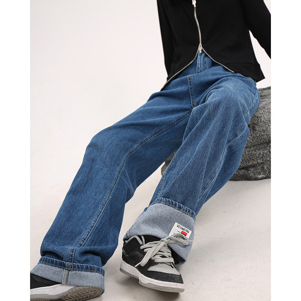 Sirge kõrge vöökohaga naiste teksapükste mudel, mille ühel säärel on embleem