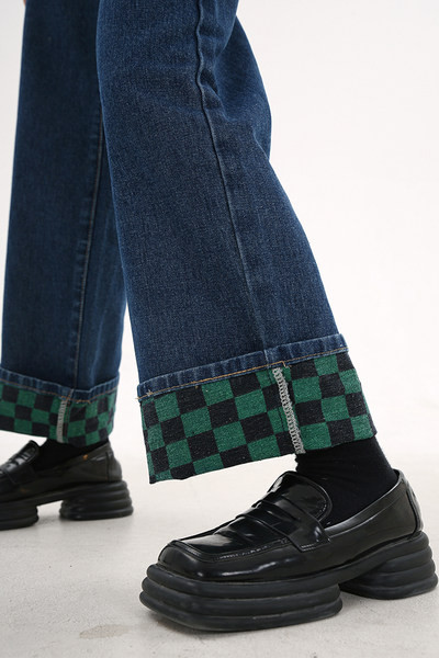 Säärde kokku keeratud naiste teksapüksid