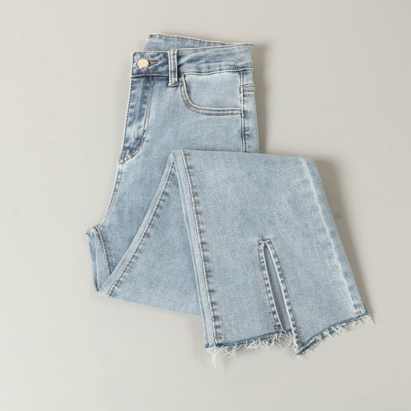 Kõrge vöökohaga lõhikutega naiste teksad, säärtel rebenenud motiivid