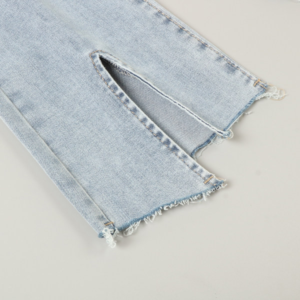 Kõrge vöökohaga lõhikutega naiste teksad, säärtel rebenenud motiivid