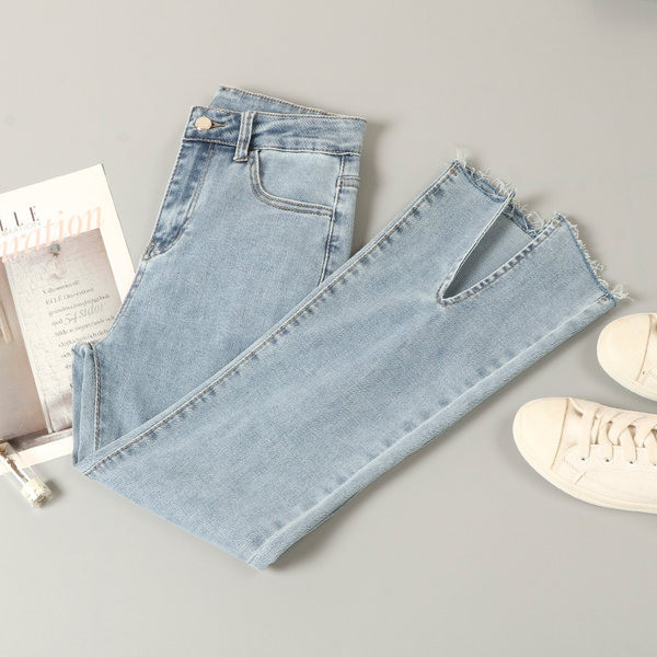 Kõrge vöökohaga lõhikutega naiste teksad, säärtel rebenenud motiivid