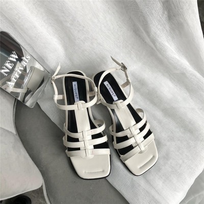 Valge ja musta värvi nahast rihmadega vabaaja sandaalid