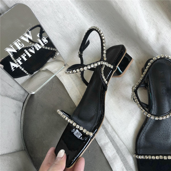 Naiste kandilised sandaalid, mille rihmadel on kivikesed