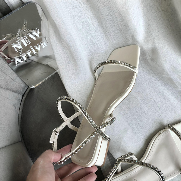 Naiste kandilised sandaalid, mille rihmadel on kivikesed