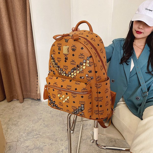 Pruuni ja musta värvi neetidega naiste seljakott