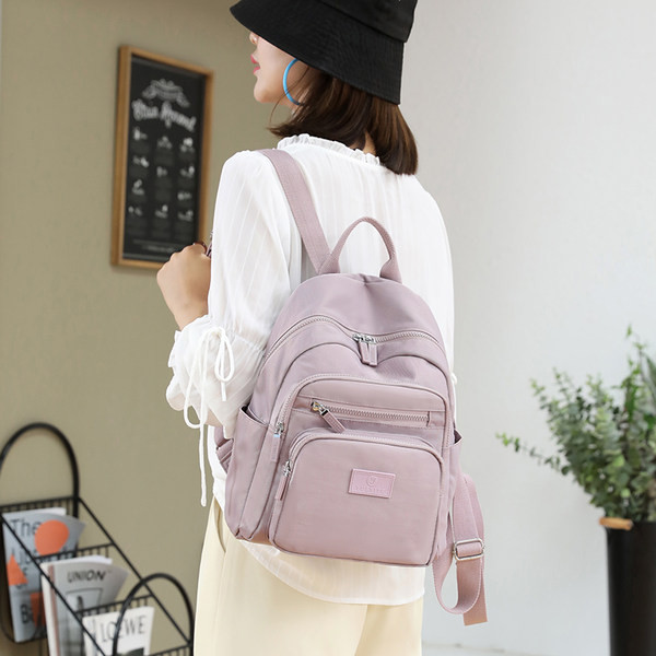 Naiste tekstiilist seljakott taskutega mitmes värvitoonis