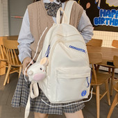 Suur riidest seljakott, millel on kiri ja plüüsist võtmehoidja