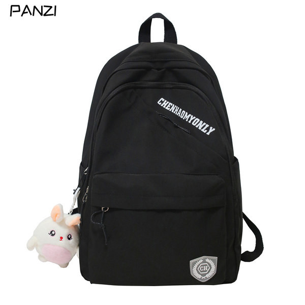 Suur riidest seljakott, millel on kiri ja plüüsist võtmehoidja