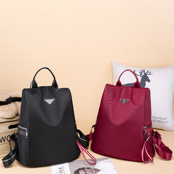 Naiste tekstiilist seljakott mitmes värvitoonis embleemiga