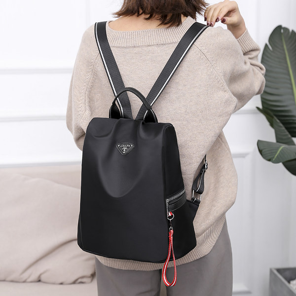 Naiste tekstiilist seljakott mitmes värvitoonis embleemiga