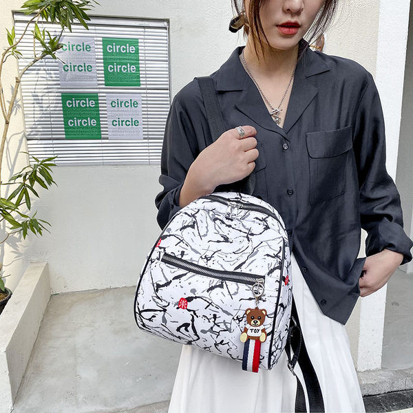 Naiste seljakott halli ja valge ripatsiga