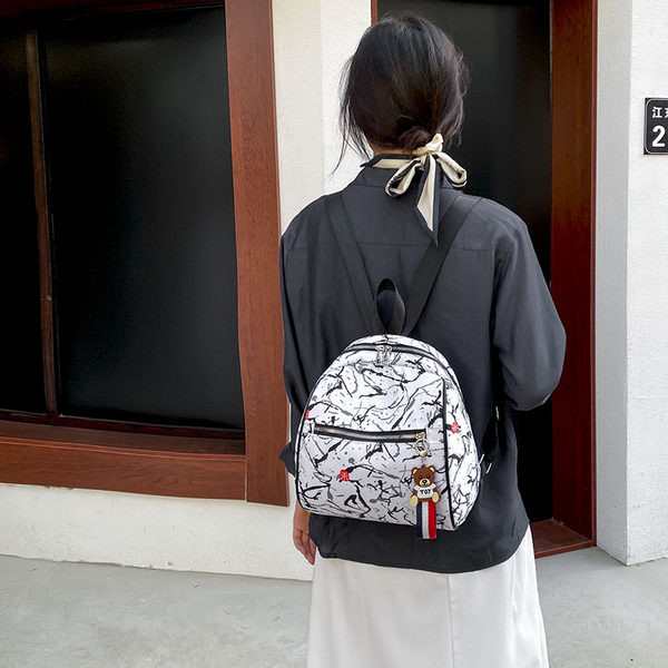 Naiste seljakott halli ja valge ripatsiga