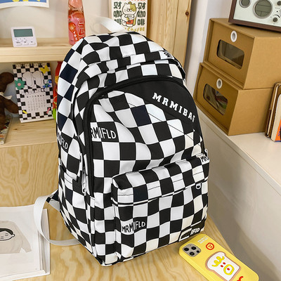 Naiste ruuduline seljakott kirja ja esitaskuga