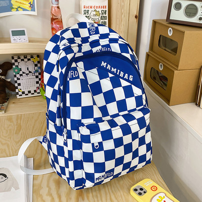 Naiste ruuduline seljakott kirja ja esitaskuga