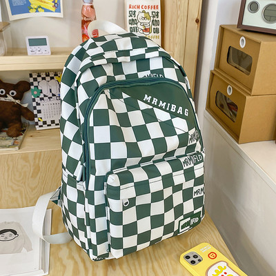 Naiste ruuduline seljakott kirja ja esitaskuga