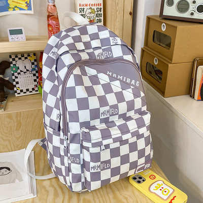 Naiste ruuduline seljakott kirja ja esitaskuga