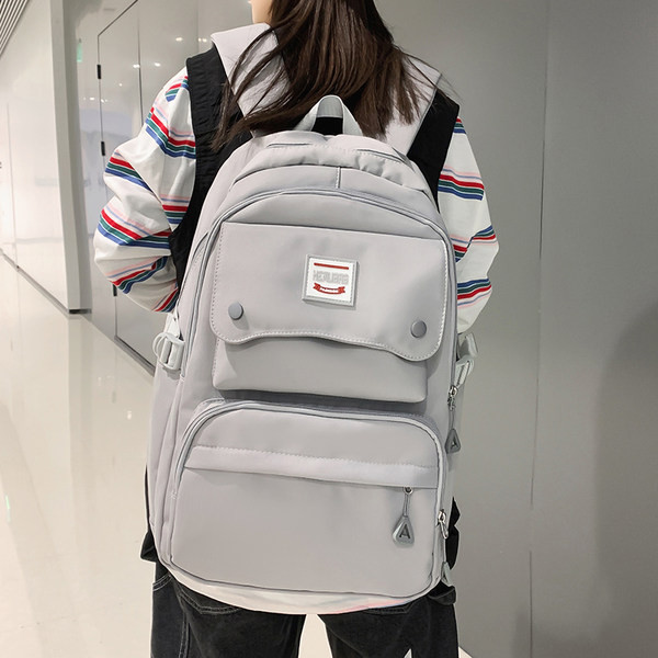 Naiste tekstiilist seljakott tasku ja embleemiga