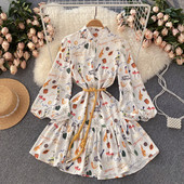 Keskmise pikkusega värvilise mustriga väljalõigatud kleit