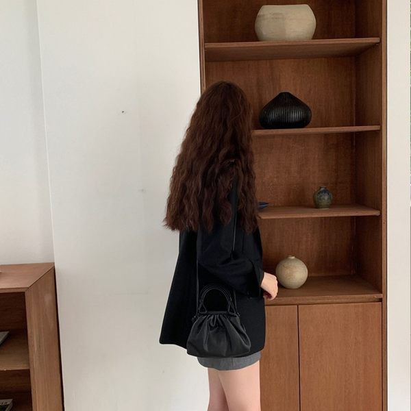 Ženska jakna crne boje jednobojni model na gumbe