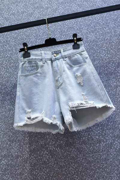 Naiste lühikesed kõrge vöökoha ja rebenenud motiividega teksapüksid