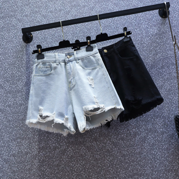 Naiste lühikesed kõrge vöökoha ja rebenenud motiividega teksapüksid