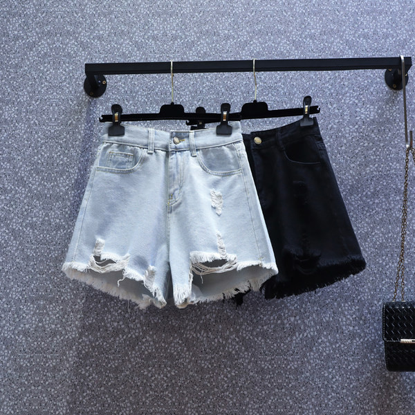 Naiste lühikesed kõrge vöökoha ja rebenenud motiividega teksapüksid