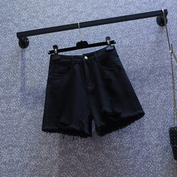 Naiste lühikesed kõrge vöökoha ja rebenenud motiividega teksapüksid