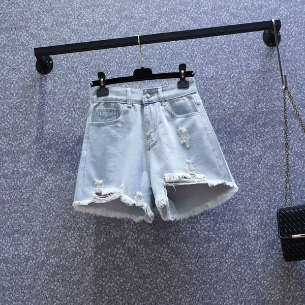 Naiste lühikesed kõrge vöökoha ja rebenenud motiividega teksapüksid