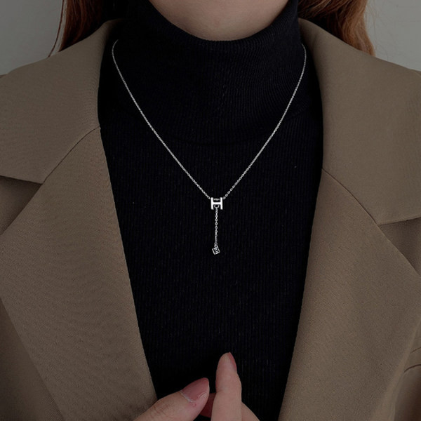 Naiste kaelakee ripatsi ja kirjaga