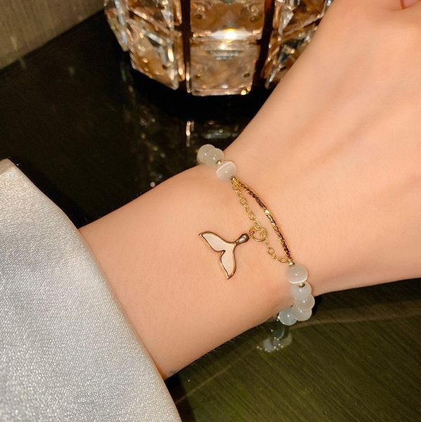 Moteriška apyrankė su baltais karoliukais ir pakabuku