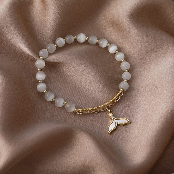 Moteriška apyrankė su baltais karoliukais ir pakabuku