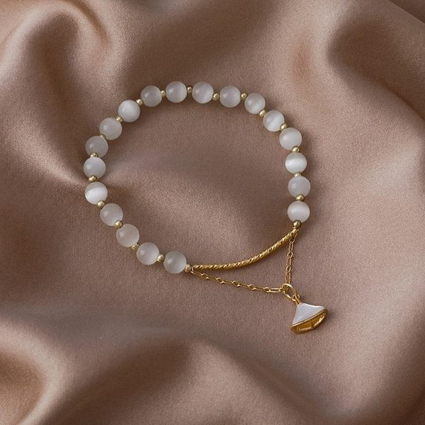 Moteriška apyrankė su baltais karoliukais ir pakabuku