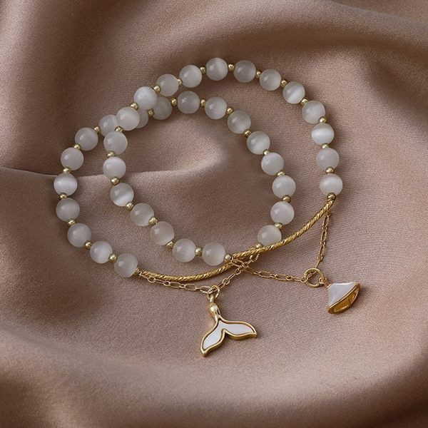 Moteriška apyrankė su baltais karoliukais ir pakabuku