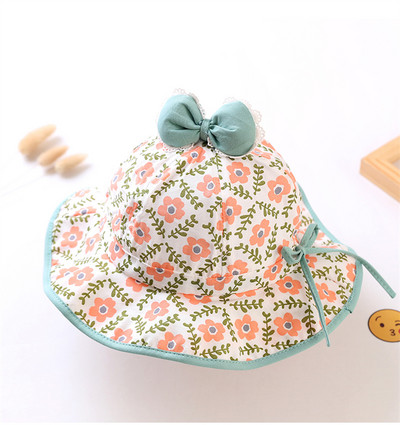 Lillemotiivide ja paelaga laste kaasaegne müts tüdrukutele