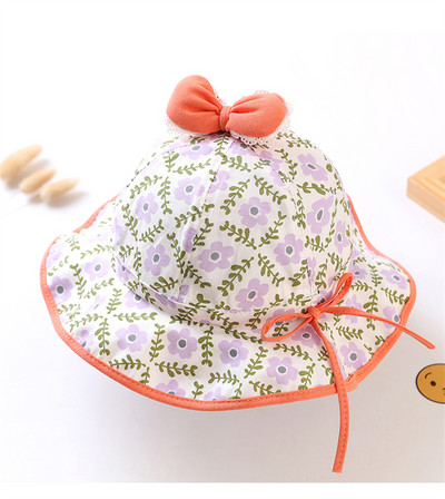 Lillemotiivide ja paelaga laste kaasaegne müts tüdrukutele