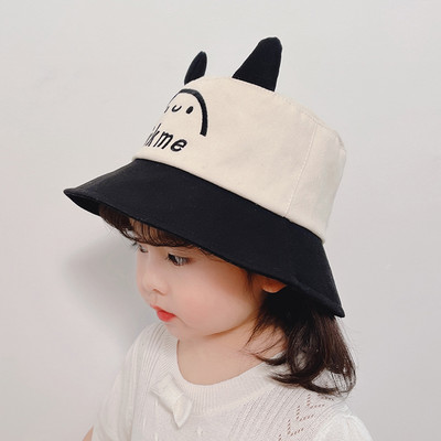 Tikitud kirjaga laste tekstiilist müts