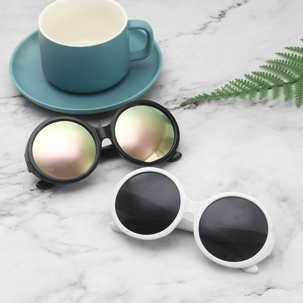 Ümarate klaaside ja plastikust värvilise raamiga päikeseprillid