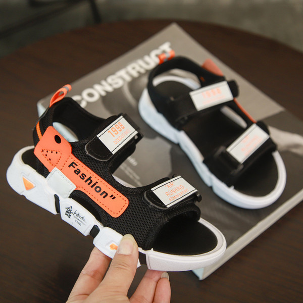 Fekete matricákkal és feliratokkal ellátott gyerekszandál