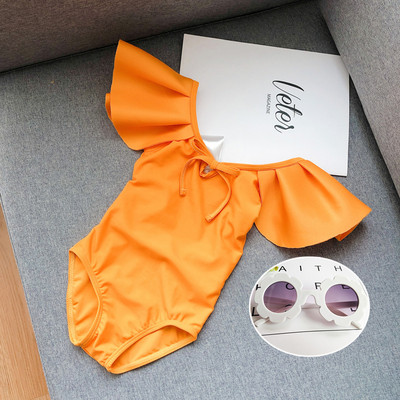 Μοντέρνο μαγιό για κορίτσια με μπούκλες και γυμνή πλάτη