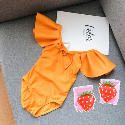 Μοντέρνο μαγιό για κορίτσια με μπούκλες και γυμνή πλάτη