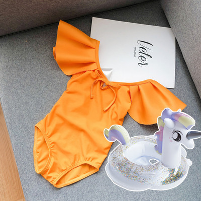 Μοντέρνο μαγιό για κορίτσια με μπούκλες και γυμνή πλάτη