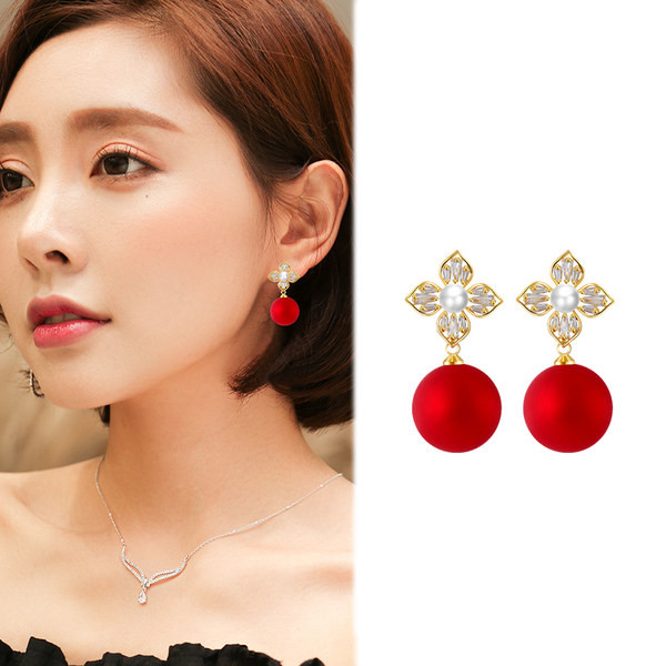 Arany színű női fülbevaló piros gyöngykövekkel