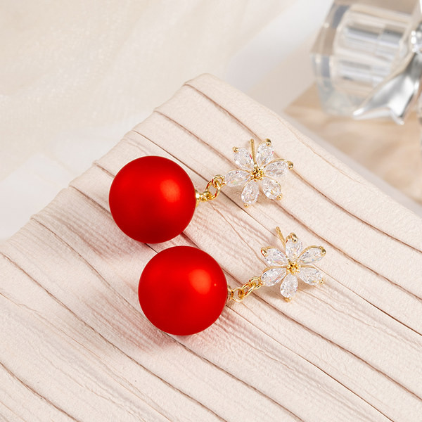 Arany színű női fülbevaló piros gyöngykövekkel