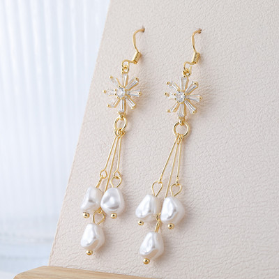 Hosszú női fülbevaló dekoratív gyöngyökkel és kövekkel, arany színben