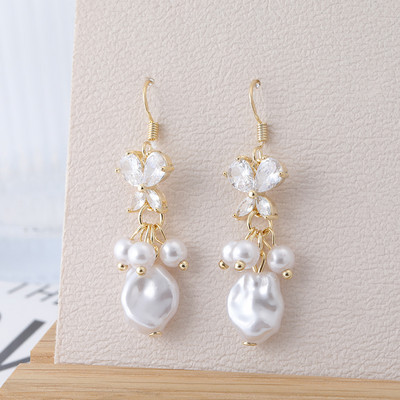 Hosszú női fülbevaló dekoratív gyöngyökkel és kövekkel, arany színben