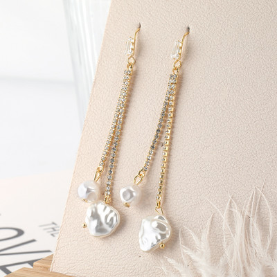 Hosszú női fülbevaló dekoratív gyöngyökkel és kövekkel, arany színben