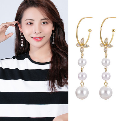 Női fülbevaló gyöngyökkel és dekoratív virágokkal és kövekkel