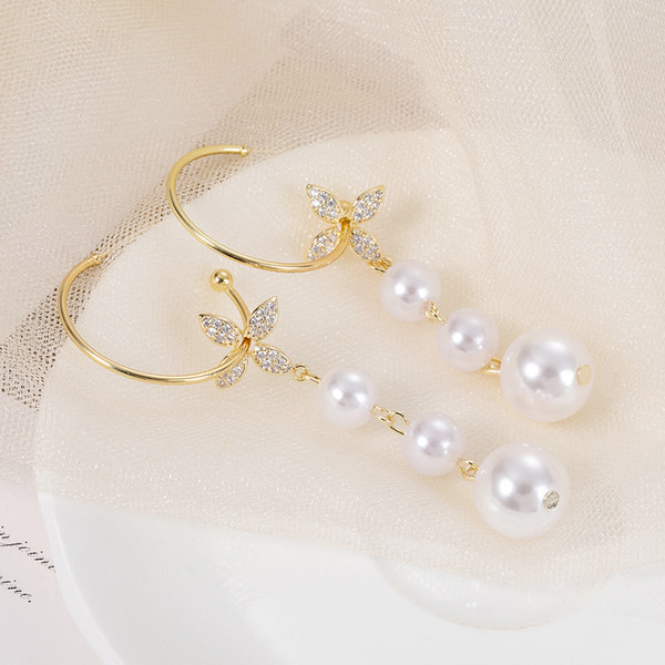 Női fülbevaló gyöngyökkel és dekoratív virágokkal és kövekkel