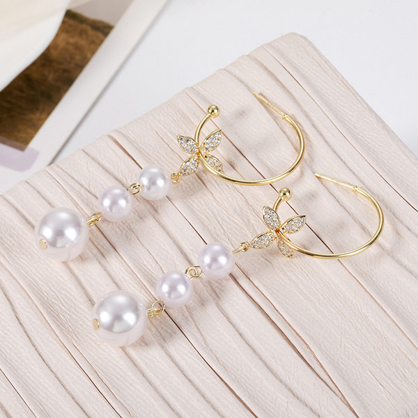 Női fülbevaló gyöngyökkel és dekoratív virágokkal és kövekkel